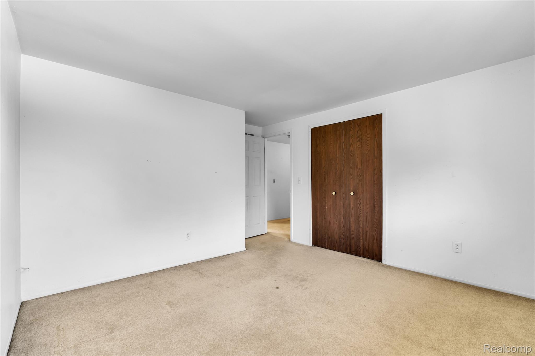 7000 Woonsocket Street Canton, MI 48187 - Photo 49 of 65 Carpeted flooring throughout the room with white painted walls and a wood-finish closet door