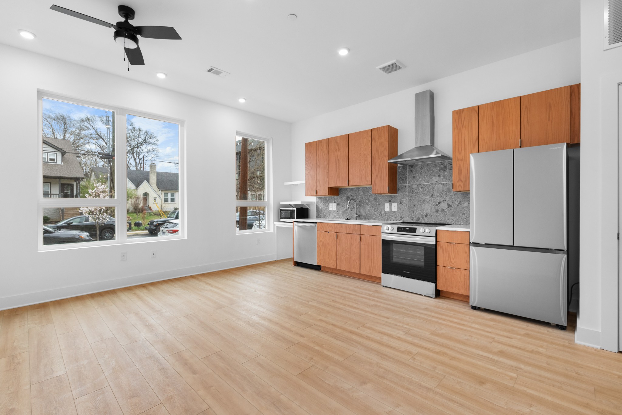 1310 Lischey Avenue, Unit 104 Nashville, TN 37207 - Photo 7 of 28 a kitchen with stainless steel appliances granite countertop a refrigerator a sink dishwasher a stove with wooden floor and cabinets