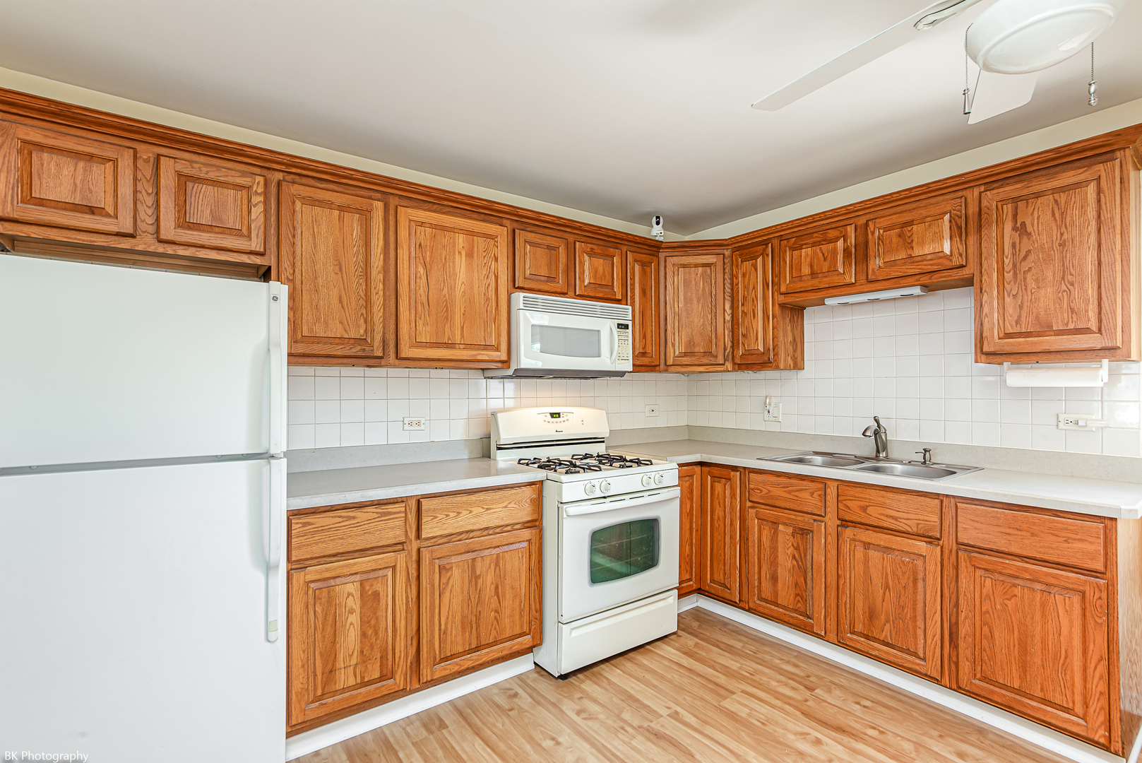 7049 West 91st Street Bridgeview, IL 60455 - Photo 7 of 25 a kitchen with stainless steel appliances granite countertop a stove a sink dishwasher and a refrigerator with wooden cabinets