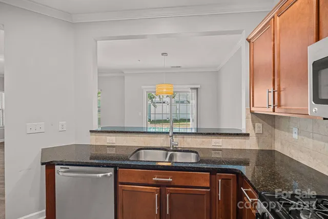 a kitchen with stainless steel appliances granite countertop a sink a stove and cabinets