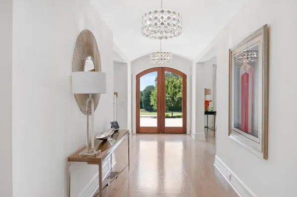 a view of a livingroom with a fireplace a flat screen tv and a chandelier