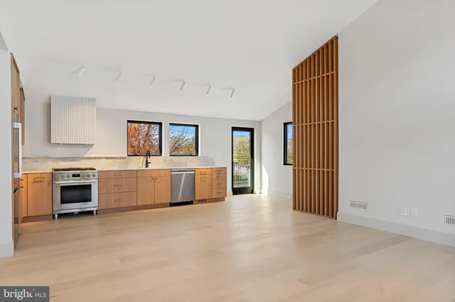 a kitchen with stainless steel appliances a stove top oven and a refrigerator