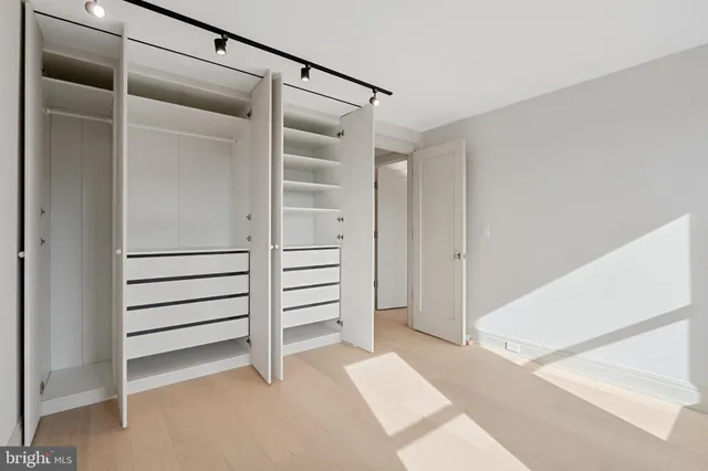 an empty room with windows and closet