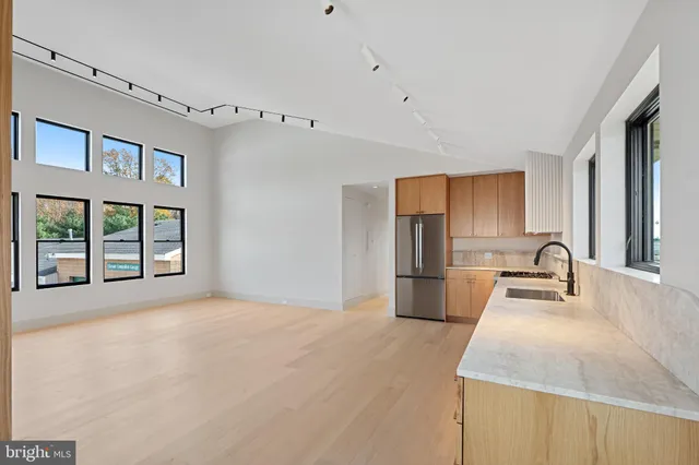 a kitchen with kitchen island a sink appliances cabinets and a large window