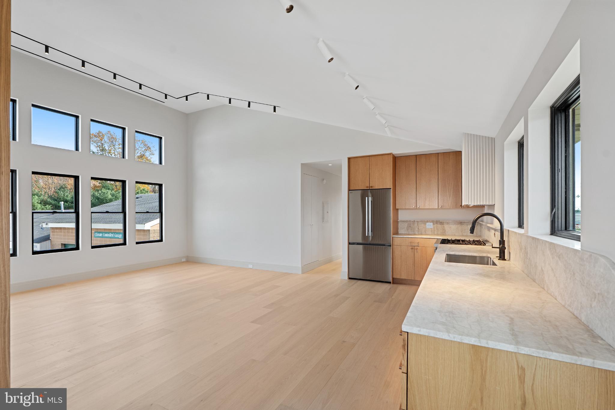 501 Haddonfield-Berlin Road, Unit 2 Voorhees, NJ 08043 - Photo 3 of 18 a kitchen with kitchen island a sink appliances cabinets and a large window
