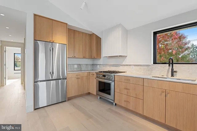 a kitchen with stainless steel appliances a refrigerator sink and cabinets