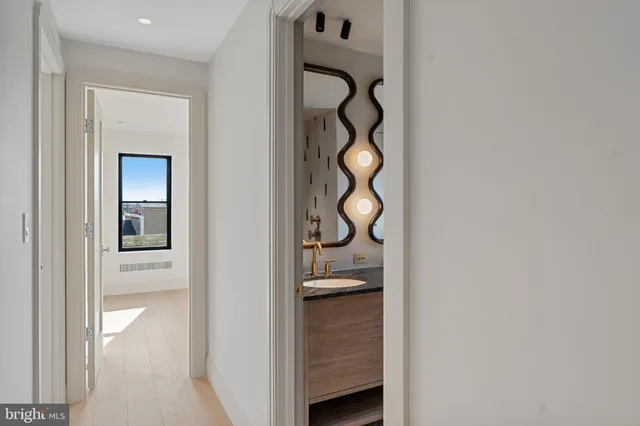 a bathroom with a granite countertop toilet a sink and a mirror