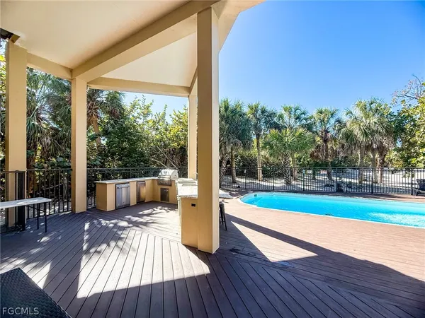 an outdoor view of patio with umbrella and wooden fence