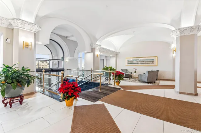 a living room with furniture flowers and a potted plant