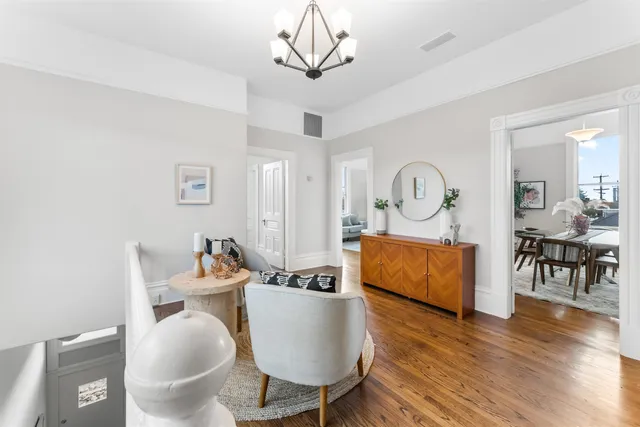a living room with furniture a dining table and a chandelier