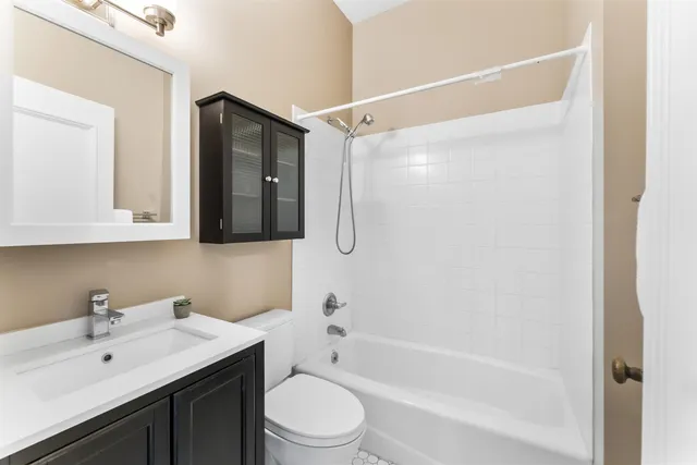 a bathroom with a bathtub shower sink vanity and toilet