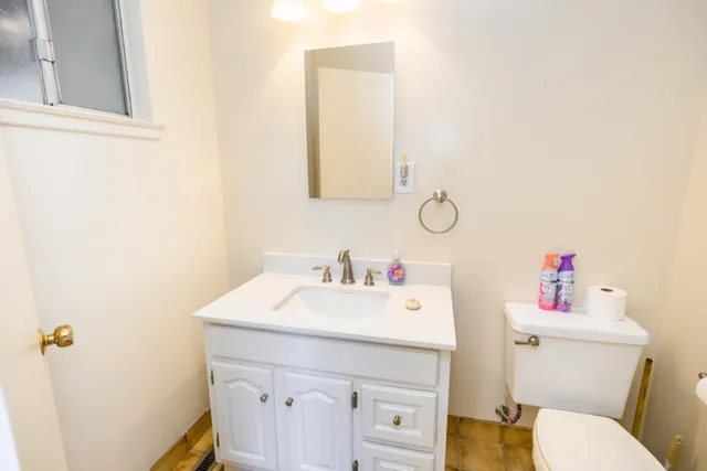 a bathroom with a sink vanity mirror and toilet