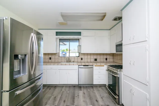 a kitchen with a sink stainless steel appliances and cabinets