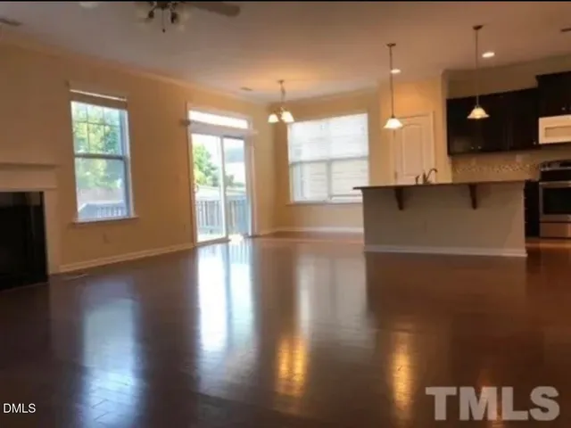 a view of an empty room with kitchen appliances and a window