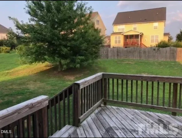 a view of a wooden deck and a yard with swimming pool