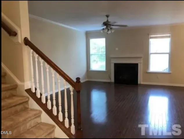 wooden floor fireplace and windows in an empty room