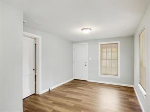 519 Sunnyside Street Cockrell Hill, TX 75211 - Photo 18 of 25 an empty room with wooden floor cabinet and windows