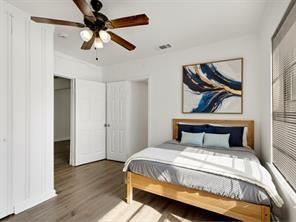 519 Sunnyside Street Cockrell Hill, TX 75211 - Photo 4 of 25 a bedroom with a bed and wooden floor