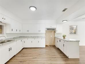 519 Sunnyside Street Cockrell Hill, TX 75211 - Photo 8 of 25 a kitchen with granite countertop white cabinets and a sink