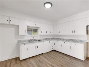 519 Sunnyside Street Cockrell Hill, TX 75211 - Photo 10 of 25 a kitchen with granite countertop a sink and cabinets