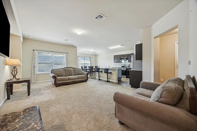 a living room with furniture and kitchen view