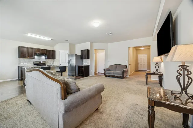 a living room with furniture a fireplace and a flat screen tv
