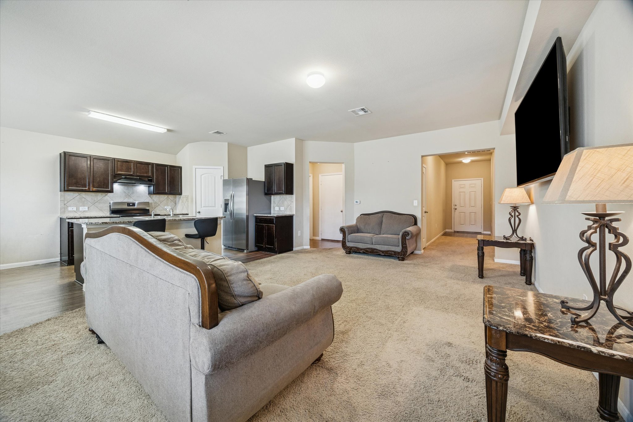 15211 Wideleaf Cove Austin, TX 78724 - Photo 5 of 15 a living room with furniture a fireplace and a flat screen tv
