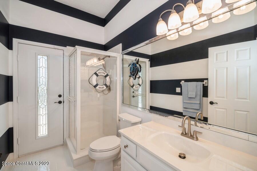 4395 Canard Road Melbourne, FL 32934 - Photo 21 of 36 a bathroom with a sink a toilet and a large mirror