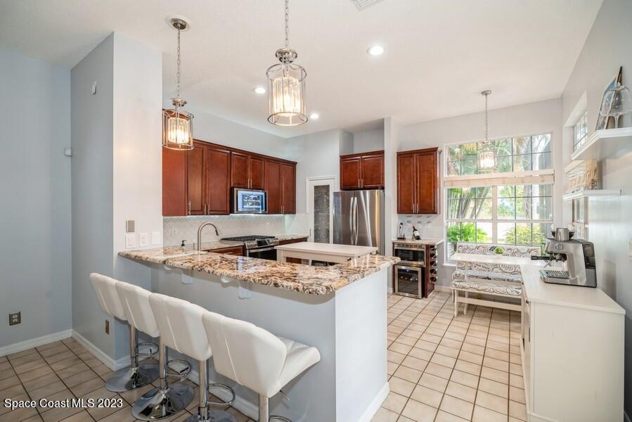4395 Canard Road Melbourne, FL 32934 - Photo 7 of 36 a kitchen with stainless steel appliances kitchen island granite countertop a sink stove and refrigerator