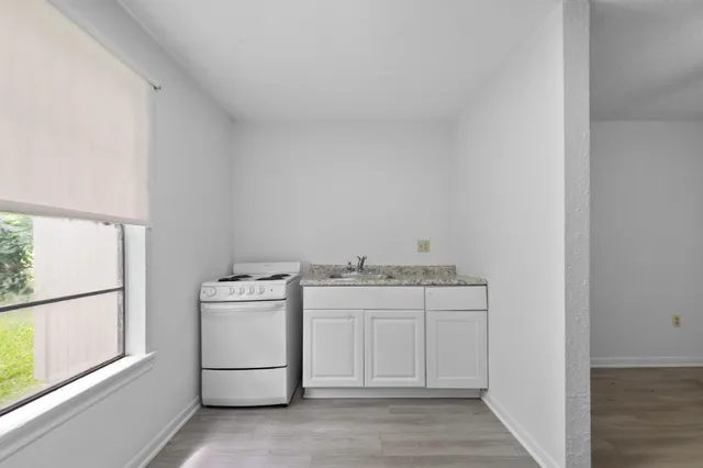 a kitchen with a stove top oven and cabinets