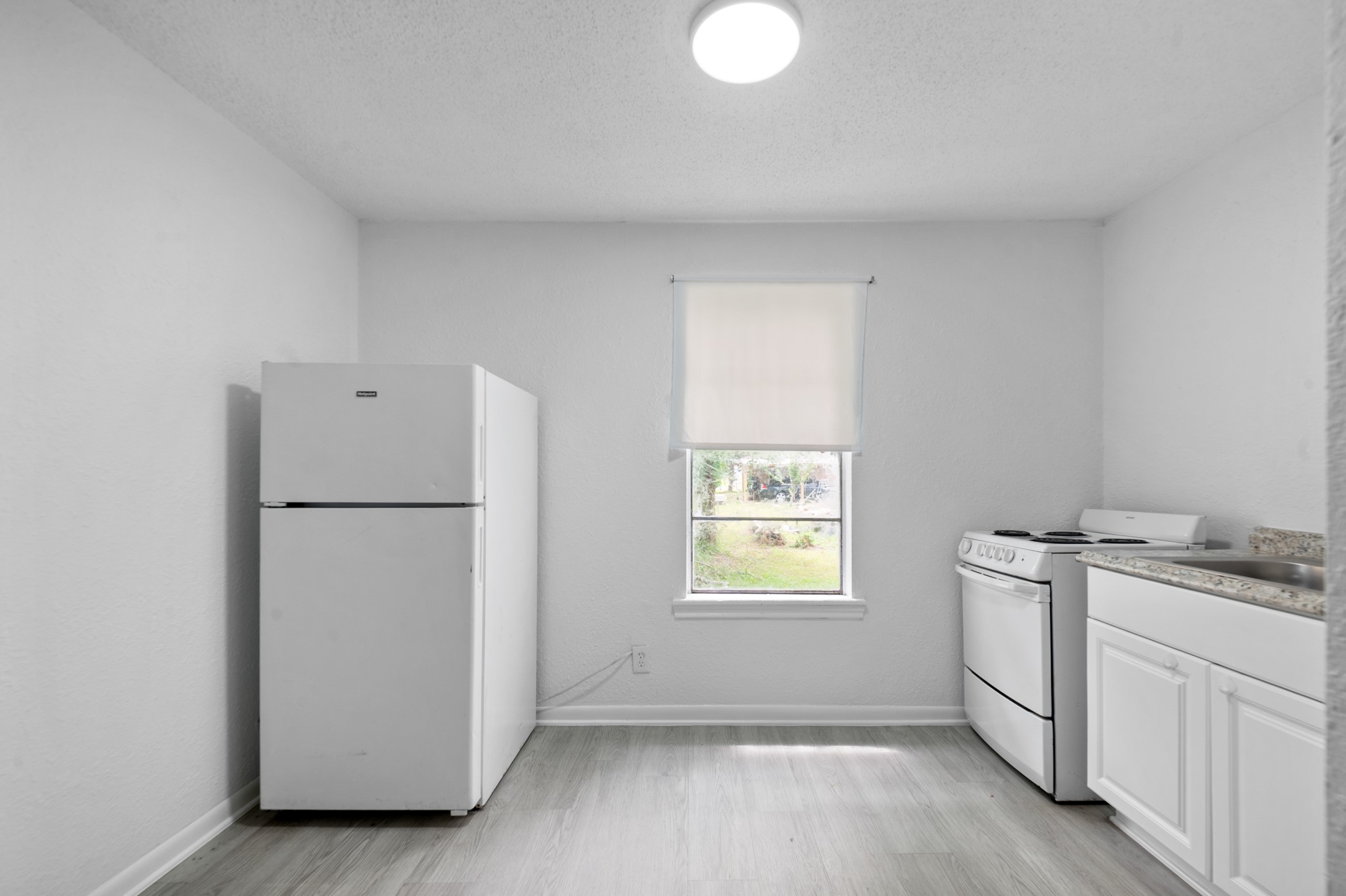 806 East Emily Avenue, Unit 1 Wharton, TX 77488 - Photo 25 of 32 a view of a kitchen with a sink dishwasher and a refrigerator