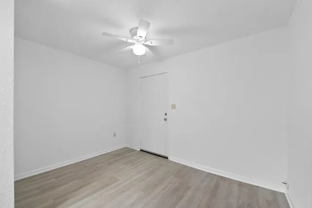 a view of an empty room with wooden floor