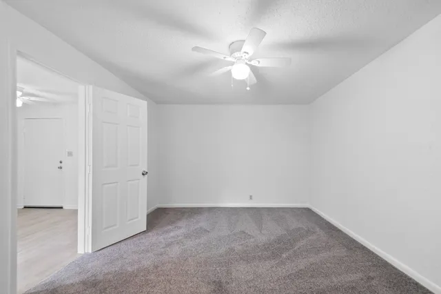 an empty room with a chandelier fan
