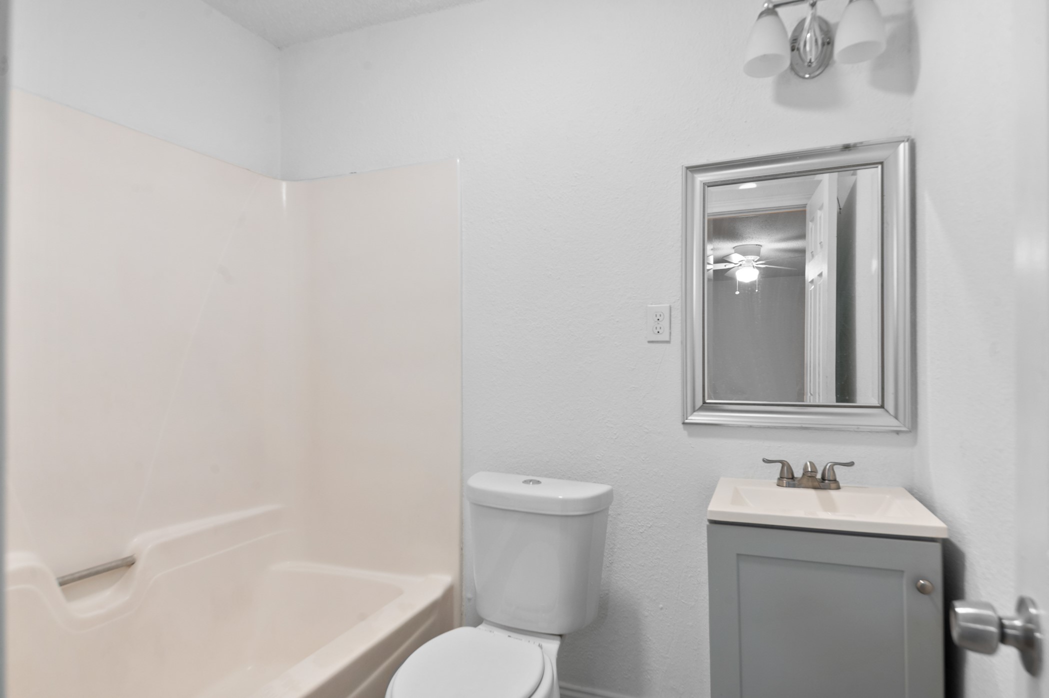 806 East Emily Avenue, Unit 1 Wharton, TX 77488 - Photo 32 of 32 a bathroom with a granite countertop toilet a sink and mirror