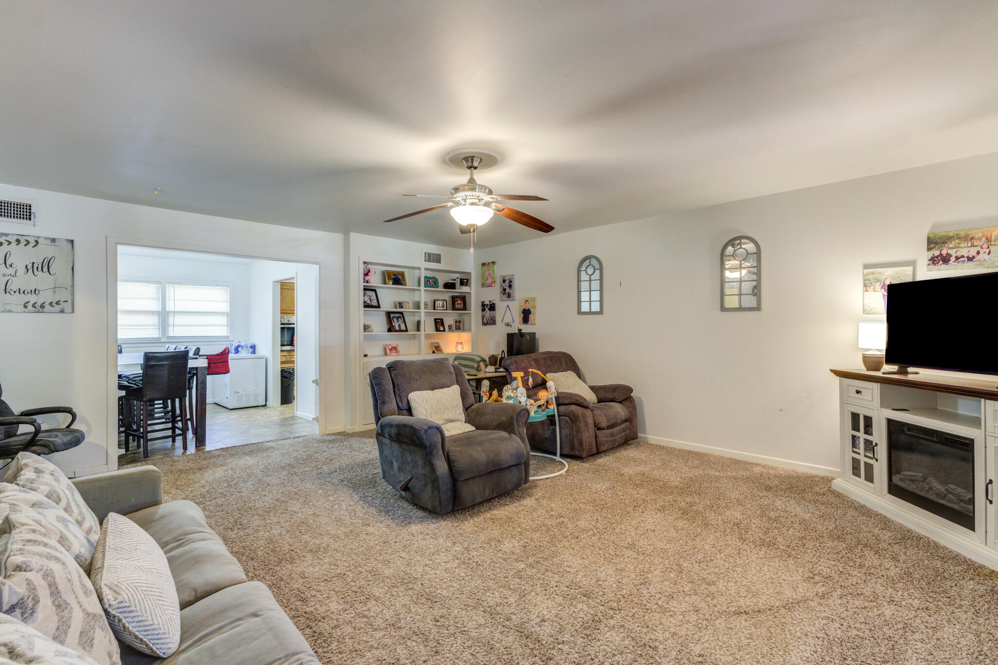 3615 37th Street Lubbock, TX 79413 - Photo 10 of 27 a living room with furniture a fireplace and a flat screen tv