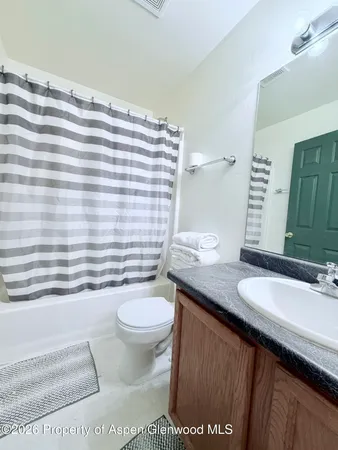 a bathroom with a granite countertop sink toilet and mirror