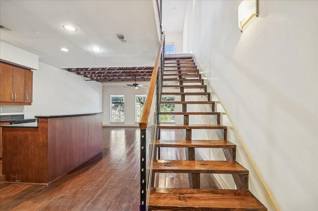 a view of a hallway with wooden floor and staircase