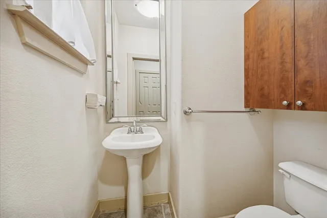 a bathroom with a sink toilet and a mirror