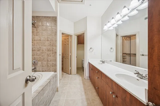 a spacious bathroom with a tub sink and mirror