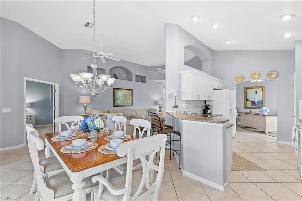 7132 Timberland Circle, Unit 201 Naples, FL 34109 - Photo 11 of 46 a view of a dining room with furniture a chandelier and kitchen view
