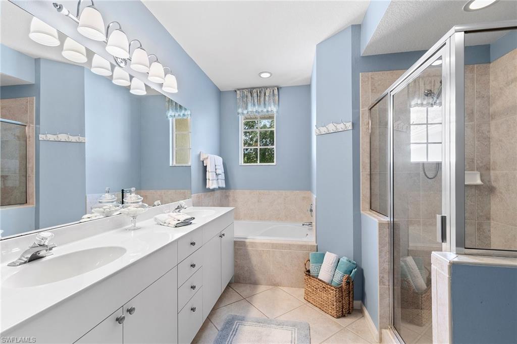 7132 Timberland Circle, Unit 201 Naples, FL 34109 - Photo 16 of 46 a spacious bathroom with a shower a sink and a mirror