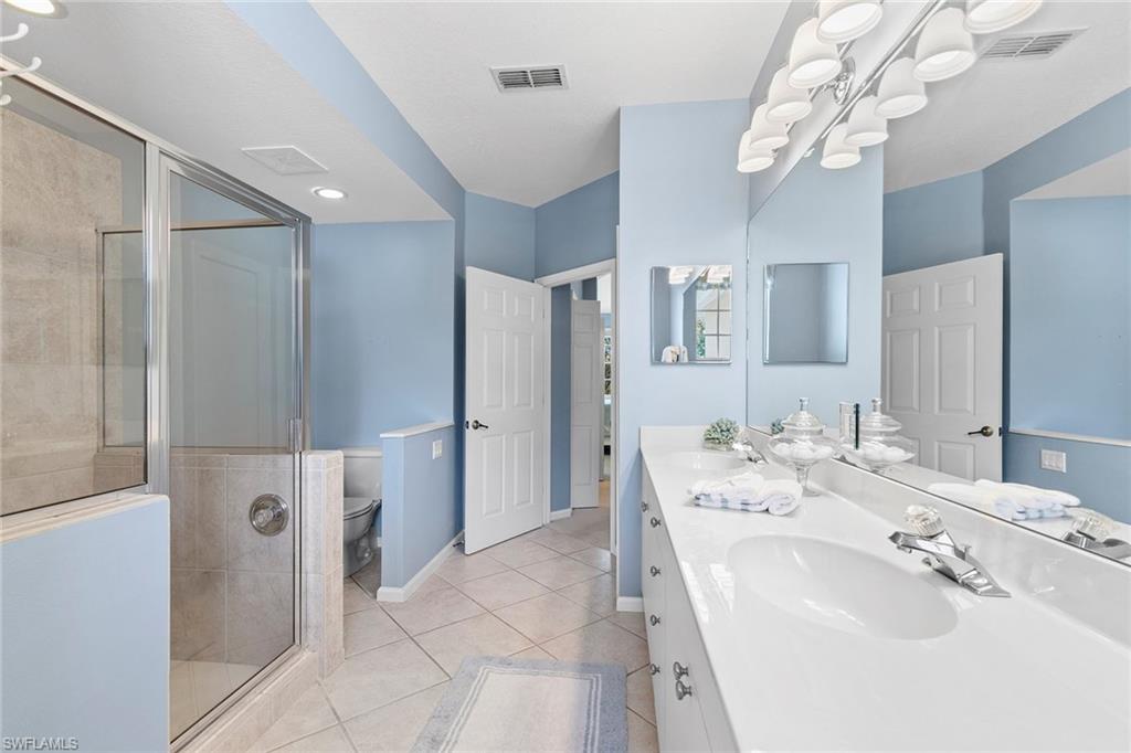 7132 Timberland Circle, Unit 201 Naples, FL 34109 - Photo 17 of 46 a spacious bathroom with a double vanity sink mirror and shower