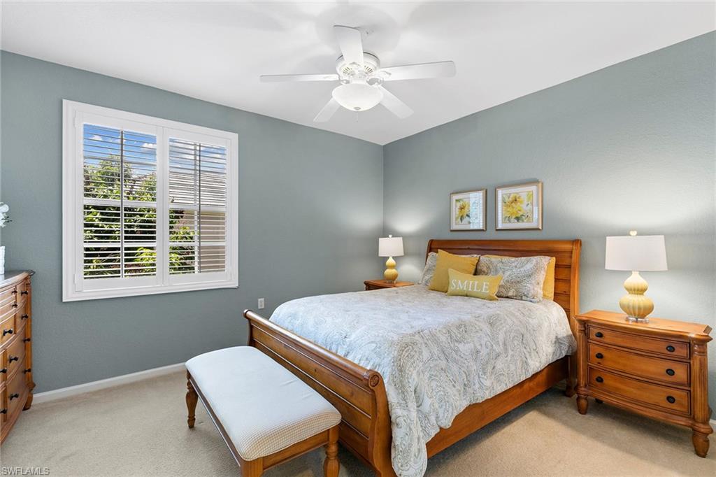 7132 Timberland Circle, Unit 201 Naples, FL 34109 - Photo 18 of 46 a bedroom with a bed and a chandelier