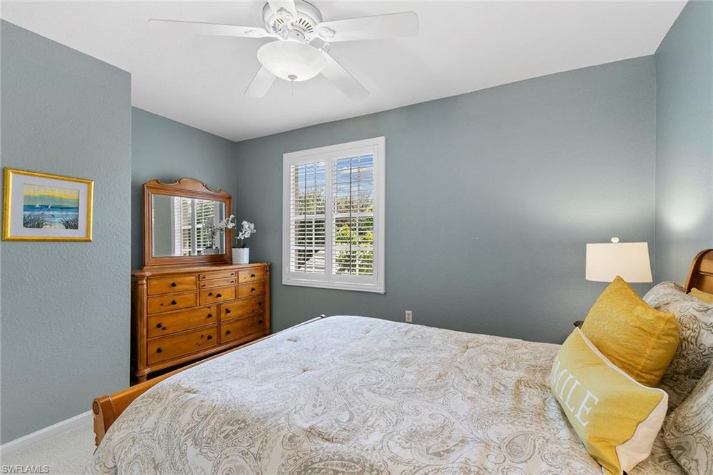 7132 Timberland Circle, Unit 201 Naples, FL 34109 - Photo 19 of 46 a bedroom with a bed and wooden floor