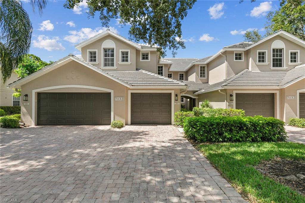 7132 Timberland Circle, Unit 201 Naples, FL 34109 - Photo 27 of 46 a front view of a house with a garden and yard