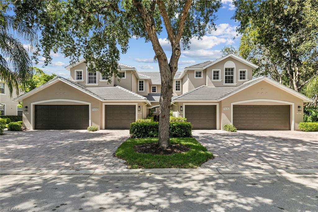 7132 Timberland Circle, Unit 201 Naples, FL 34109 - Photo 28 of 46 a front view of a house with a yard and garage