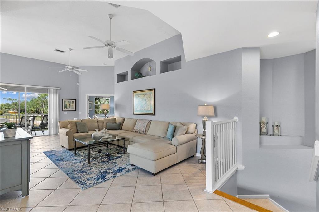 7132 Timberland Circle, Unit 201 Naples, FL 34109 - Photo 3 of 46 a living room with furniture and a chandelier