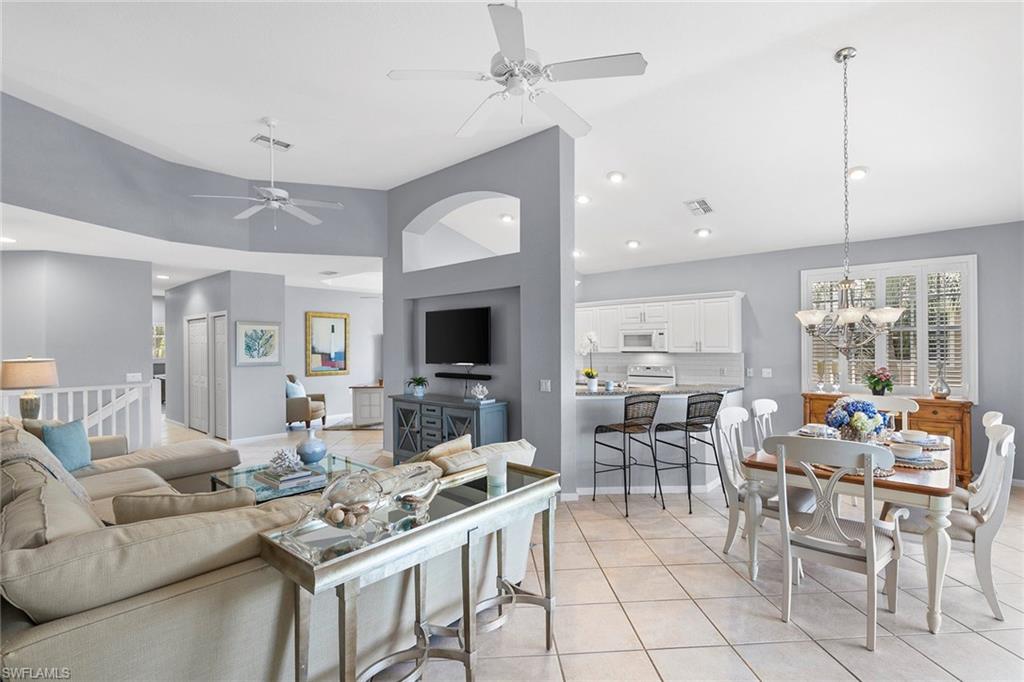 7132 Timberland Circle, Unit 201 Naples, FL 34109 - Photo 5 of 46 a living room with furniture a flat screen tv and a large window