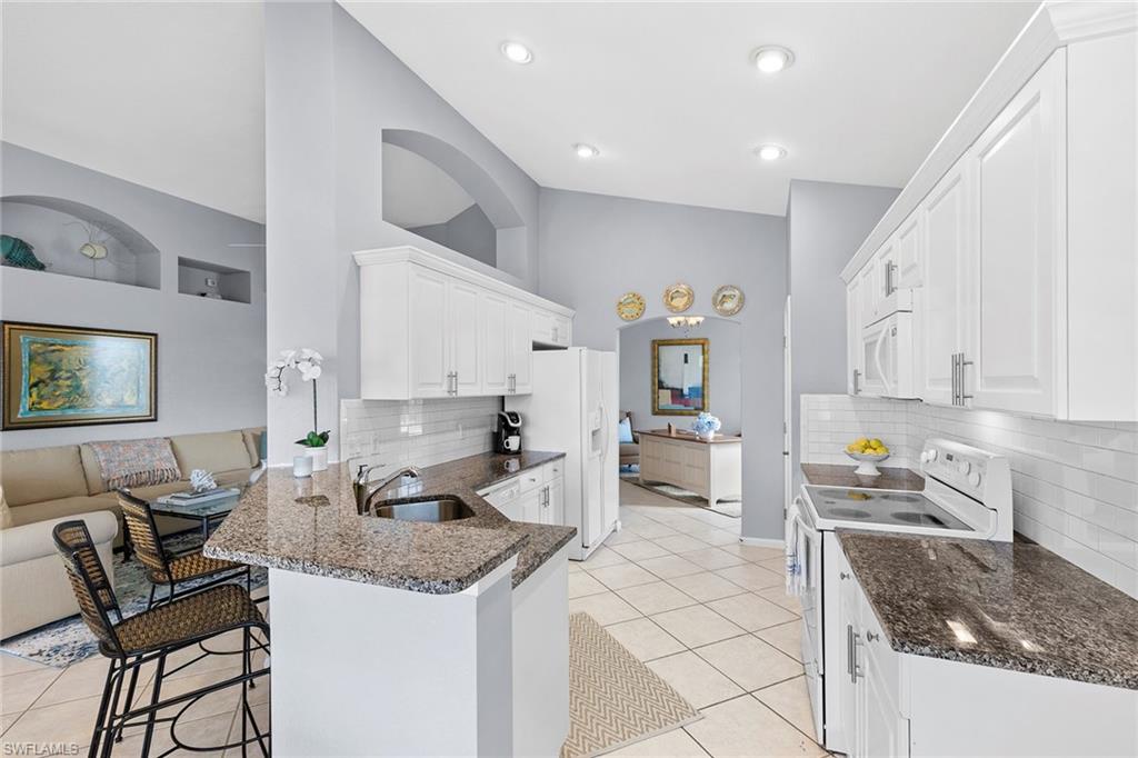 7132 Timberland Circle, Unit 201 Naples, FL 34109 - Photo 6 of 46 a kitchen with stainless steel appliances granite countertop a sink and a stove