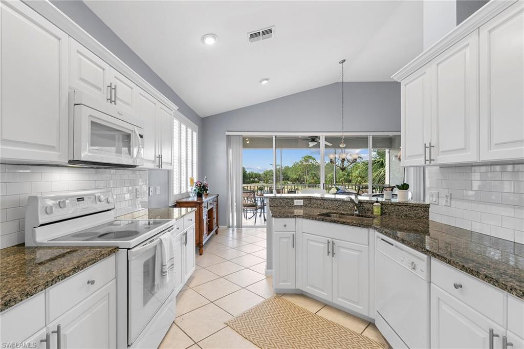 7132 Timberland Circle, Unit 201 Naples, FL 34109 - Photo 7 of 46 a kitchen with stainless steel appliances granite countertop a sink a stove and cabinets